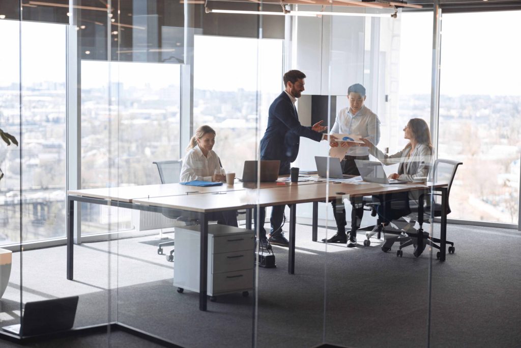 Uma sala de reuniões corporativa com pessoas interagindo.