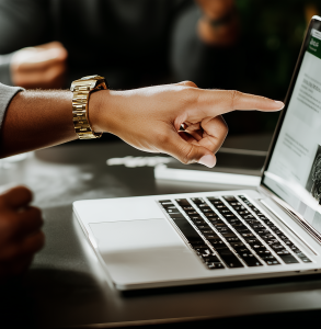 Gestor apontando para relatórios no notebook enquanto identifica travas na gestão financeira e analisa a eficiência da PME.