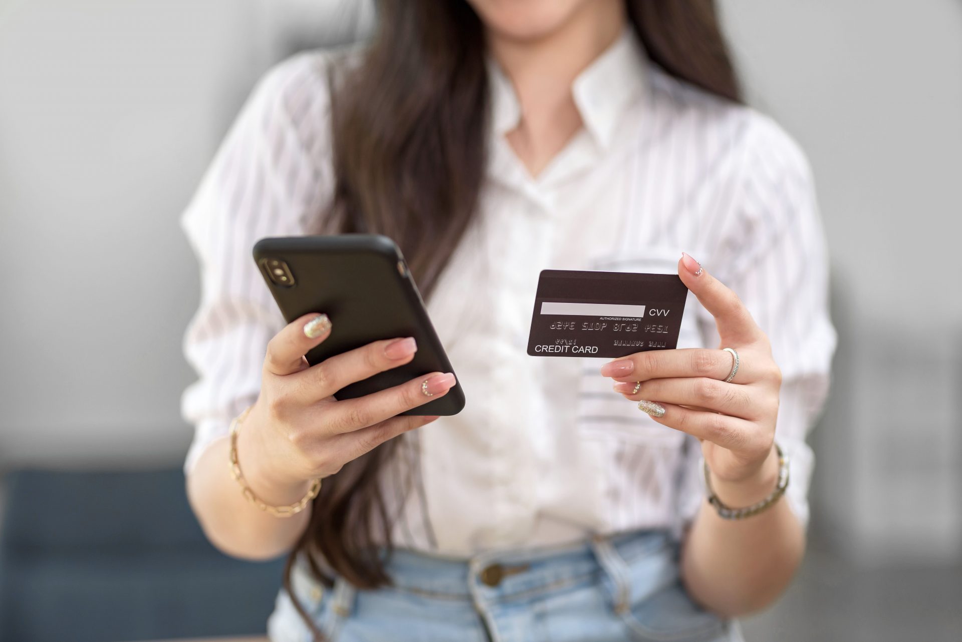 close-up-woman-holding-smartphone-and-using-credit-card-for-online-shopping